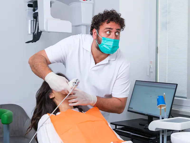 Dottore che esegue uno scanner intraorale ad una paziente