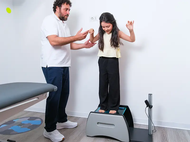Dottore che controlla l'equilibrio di una bambina 