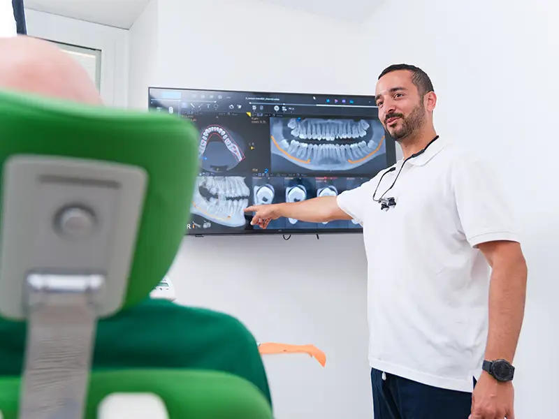 Dottore indica lo schermo con impianti dentali