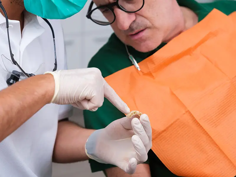 Dottore indica una protesi dentale